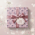 Elegant gift wrapped in pink floral wrapping paper with satin ribbon and "A special something just for you" tag.