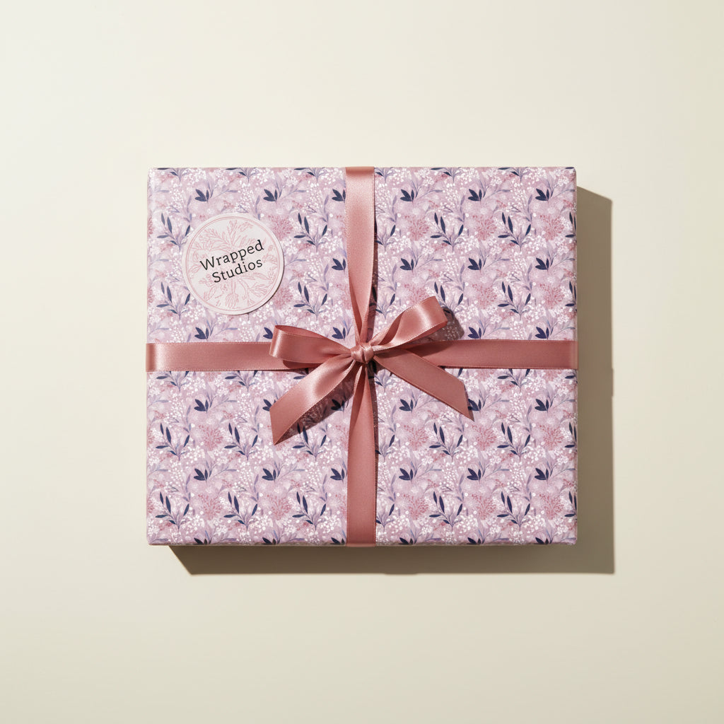 Square gift wrapped in floral wrapping paper with a rose ribbon and bow.