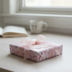 Elegant gift wrapped in pink floral wrapping paper with sheer ribbon, perfect for birthday or baby shower.