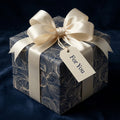 Elegant navy floral wrapping paper with ivory ribbon and "For You" gift tag, Wrapped Studios.