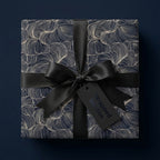 Elegant Wrapped Studios gift with navy/gold swirl wrapping paper and black satin ribbon.