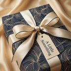 Elegant navy blue wrapping paper with gold swirl pattern and ivory ribbon from Wrapped Studios.