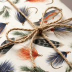 Rustic fly fishing wrapping paper with trout and lures, tied with twine by Wrapped Studios.