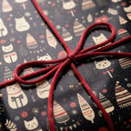 Cute cat Christmas wrapping paper with a festive tree pattern and red string bow by Wrapped Studios.