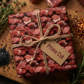 Humorous meat-themed wrapping paper on a gift box, tied with twine and a tag that says "Prime Cut."