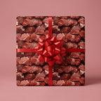 Square gift box in custom wrapping paper featuring meat pattern with a red ribbon and bow.