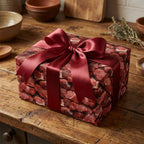 Unique gift wrapping: Square box wrapped in meat-patterned paper with a satin burgundy ribbon on a rustic wooden table.