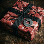Square gift wrapped in raw meat patterned wrapping paper with black cord ribbon and a 'do not cook' tag.