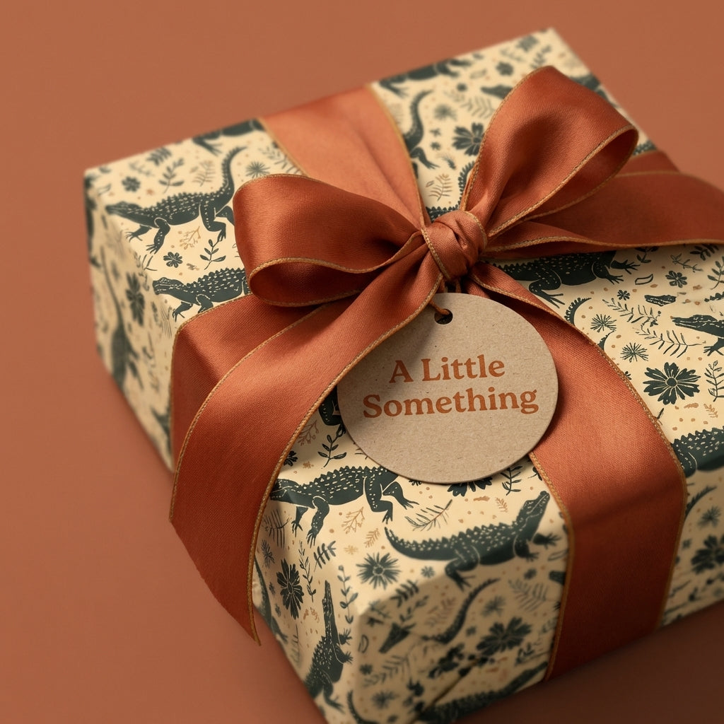 Luxury crocodile & botanical wrapping paper in cream & dark green with a rust satin bow. By Wrapped Studios.