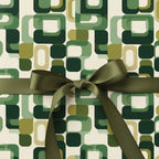 Retro geometric wrapping paper in shades of green, finished with a satin olive ribbon.
