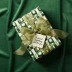 Olive green gift wrapped in retro geometric wrapping paper with a sheer ribbon and "A special something just for you" tag.