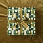 Olive green retro geometric wrapping paper with "With Love" tag and ribbon on a textured surface.
