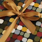 Gift wrapped in colorful retro-patterned wrapping paper with a gold satin ribbon and bow.