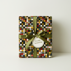 Gift box in retro-style wrapping paper with olive green ribbon and tag.