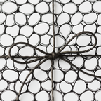 Modern black and white abstract pebble pattern wrapping paper with a simple dark twine bow, perfect for minimalist gift wrap.