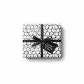 Modern black and white bubble pattern wrapping paper with a black ribbon bow and a "A Little Something Special" gift tag.