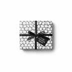 Modern black and white bubble pattern wrapping paper with a black ribbon bow and a "A Little Something Special" gift tag.