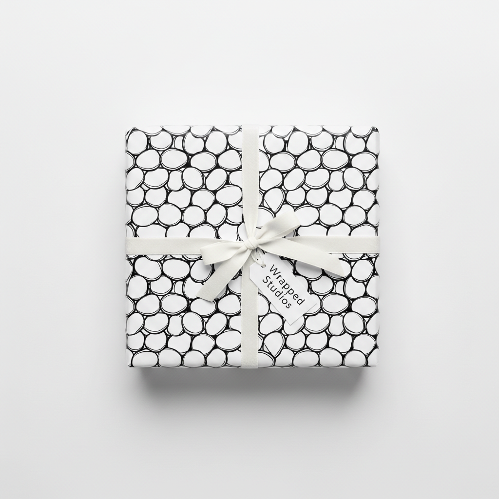 Modern black and white pebble pattern wrapping paper with a white ribbon and "Wrapped Studios" gift tag, perfect for any occasion.