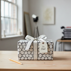 Modern black and white geometric wrapping paper with a cream ribbon and "To Dad" gift tag, perfect for a Father's Day or birthday gift.