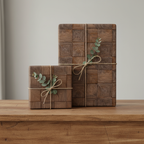 Two gifts wrapped in modern wood grain wrapping paper with twine bows and eucalyptus sprigs.