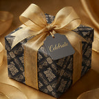 Luxury black and gold damask wrapping paper with a sheer gold ribbon and Celebrate tag by Wrapped Studios.