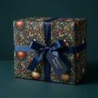 Christmas gift wrapped in botanical ornament pattern paper with navy ribbon and tag. Wrapped Studios.