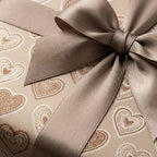 Luxury heart wrapping paper with a champagne satin bow by Wrapped Studios, perfect for Valentine's Day gifts.