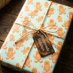 Mint green gingerbread man Christmas wrapping paper with a twine bow and rustic gift tag by Wrapped Studios.