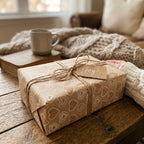 Rustic heart wrapping paper on a cozy gift tied with twine and a Joy tag, by Wrapped Studios.