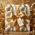 Luxury gold botanical wrapping paper with a satin bow and "With Love" gift tag by Wrapped Studios.