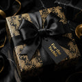 Luxury black and gold tech circuit board gift wrap with a satin bow by Wrapped Studios.