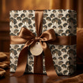 Elegant ginkgo leaf wrapping paper with a brown satin bow on a gift box by Wrapped Studios.