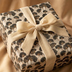 Luxury ginkgo leaf wrapping paper with a cream velvet bow on a gift box by Wrapped Studios.