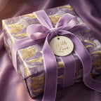 Elegant purple and gold marble pattern luxury gift wrap with velvet ribbon and "With Love" tag.