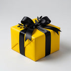 Bright yellow gift box wrapped with a satin black ribbon and bow, perfect for modern birthday or holiday wrapping paper.