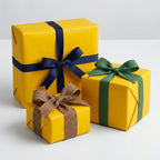 Three wrapped gifts using yellow wrapping paper with blue, green, and burlap ribbons on a white surface.