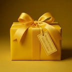 Golden yellow gift box mockup wrapped in solid color paper with satin bow and branded gift tag.