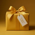 Elegant gold wrapping paper on a square gift with satin bow and gift tag.