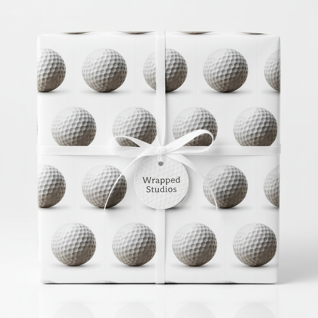 Golf ball wrapping paper from Wrapped Studios tied with a white ribbon and gift tag.