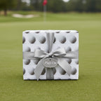Square gift wrapped in golf ball wrapping paper with a silver ribbon and “Play On” tag.