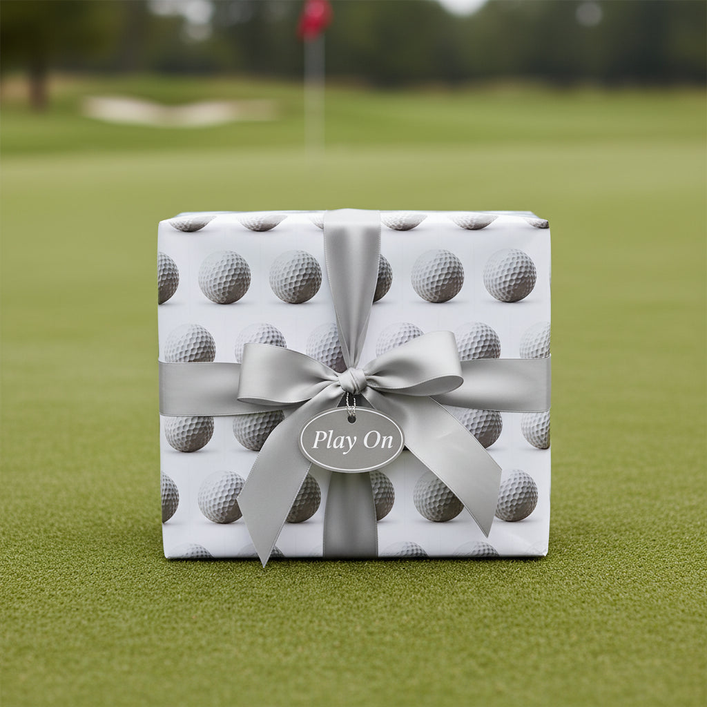 Square gift wrapped in golf ball wrapping paper with a silver ribbon and “Play On” tag.