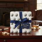 Gift wrapped in golf ball patterned wrapping paper with a navy ribbon and "Best Dad By Par" tag.