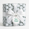 Golf wrapping paper with a white satin bow and Tee Time tag on a gift box by Wrapped Studios.