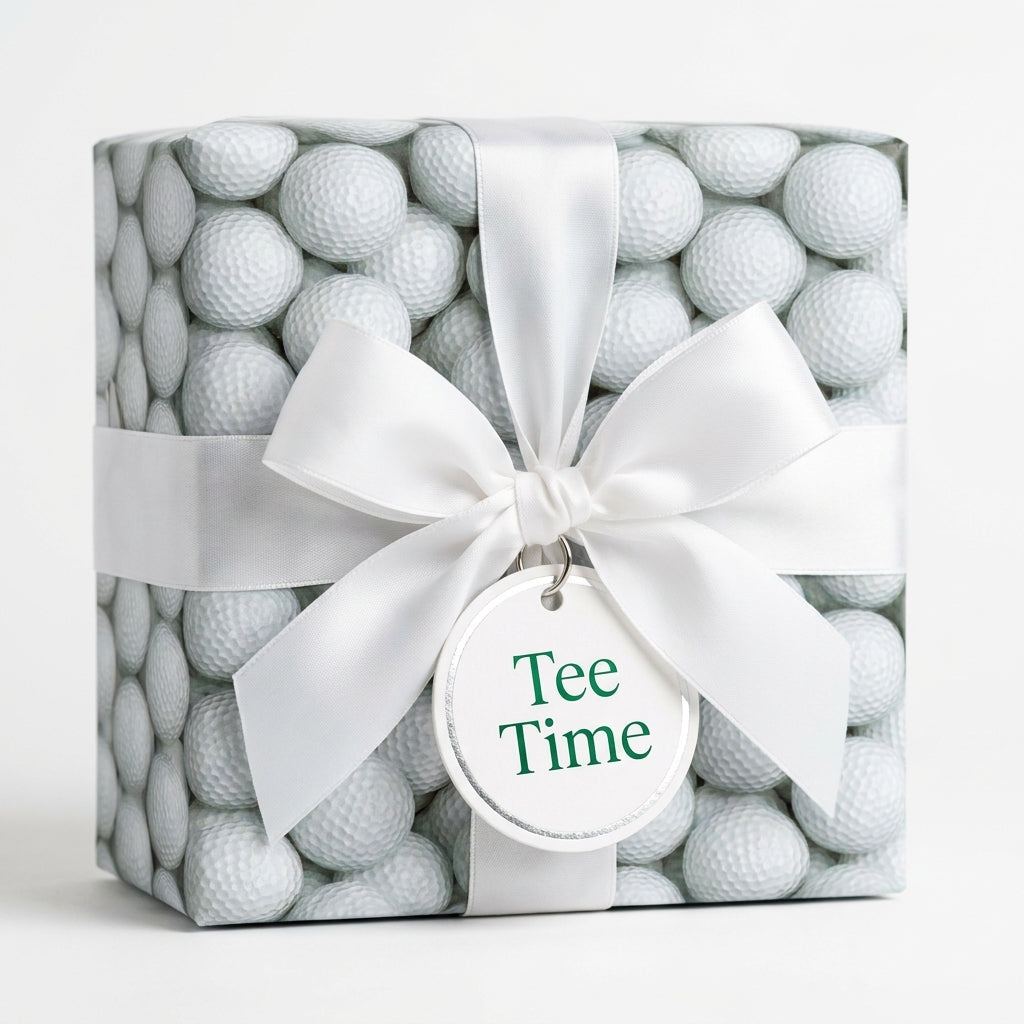 Golf wrapping paper with a white satin bow and Tee Time tag on a gift box by Wrapped Studios.