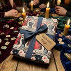 Fantasy dragon wrapping paper with a navy ribbon on a magical candlelit table by Wrapped Studios.