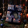 Luxury gothic witchy wrapping paper with blue velvet bow and Merry Witchmas tag, by Wrapped Studios.