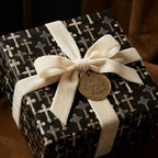 Black religious cross wrapping paper with a luxury cream velvet bow by Wrapped Studios.