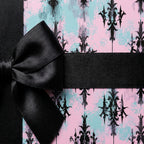 Pink and teal pastel goth wrapping paper with a black damask design and satin bow by Wrapped Studios.