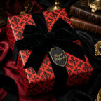 Luxury red and black gothic wrapping paper with fleur-de-lis pattern and velvet bow by Wrapped Studios.