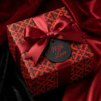 Luxury red and black gothic wrapping paper with a satin ribbon and 'With Love' tag by Wrapped Studios.
